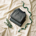 Two charcoal Storm Kit wraps folded on cream linen
